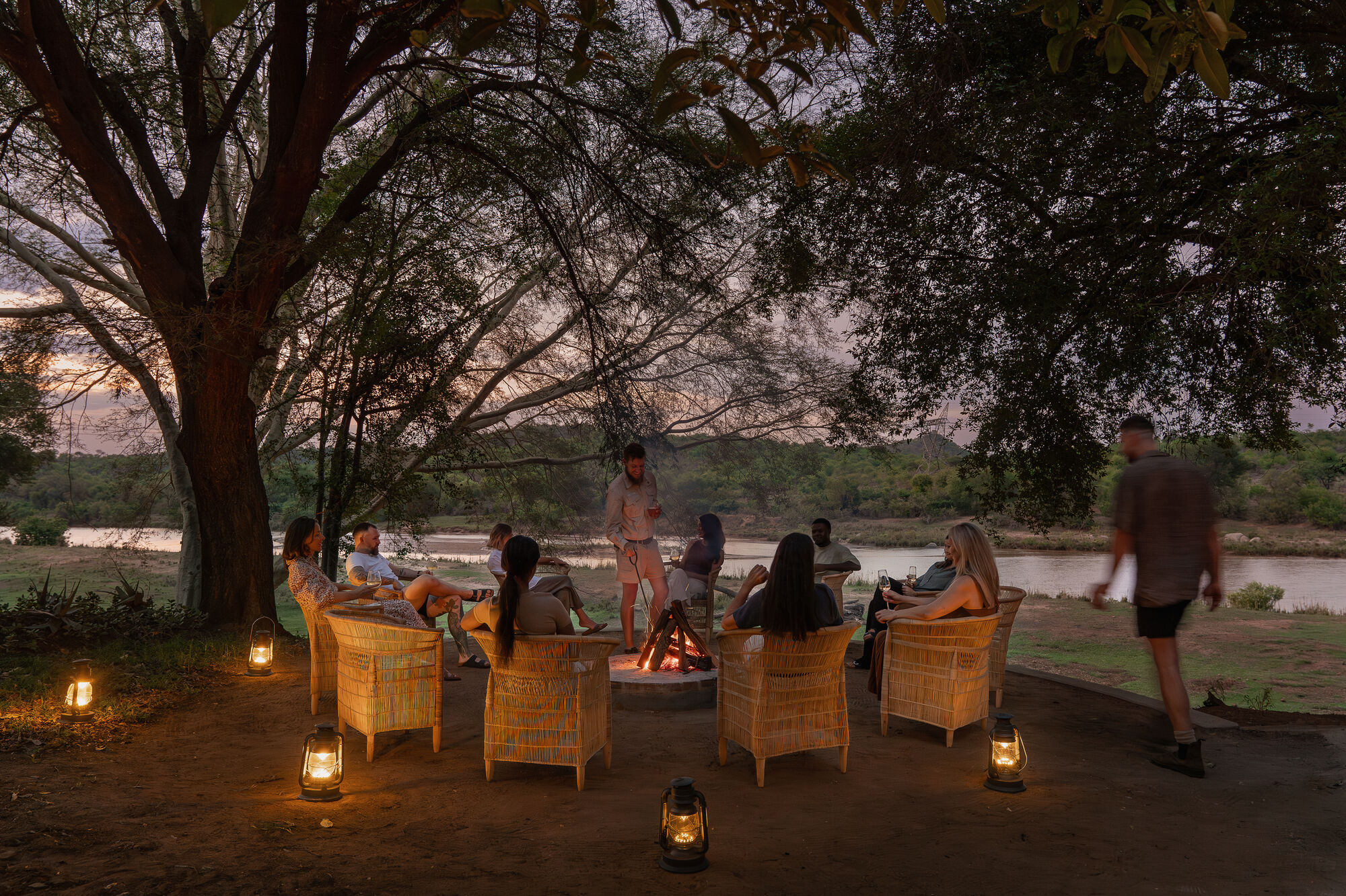 Fire circle gathering at golden hour in the African wilderness
